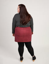 Person wearing a black and white striped shirt with a red skirt on a plain background. This skirt is the Ellis Denim Skirt sewing pattern from Cashmerette.