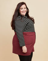 Person wearing a black and white striped shirt with a red skirt on a plain background. This skirt is the Ellis Denim Skirt sewing pattern from Cashmerette.