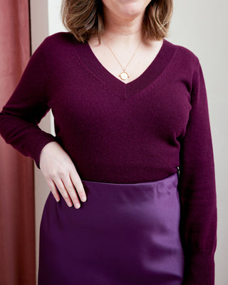 Person wearing a purple sweater and skirt with a neutral background. This skirt is the Astell Bias Skirt sewing pattern from Cashmerette.