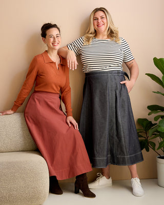 Two women posing together in front of a beige wall with a plant. This is the Osgood Skirt sewing pattern from Cashmerette.