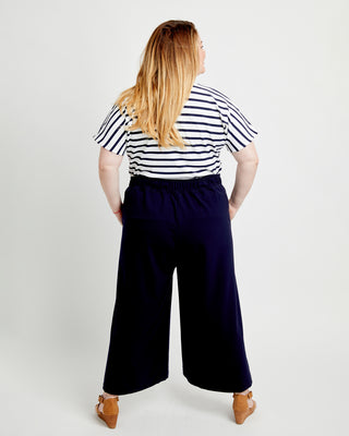 Person wearing a striped shirt and wide-leg pants on a white background. These pants are the Calder Pants & Shorts sewing pattern from Cashmerette.