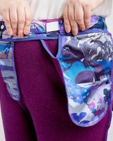 Purple pants worn inside out with a colorful patterned waistband. These pants are the Meriam Trousers sewing pattern from Cashmerette.