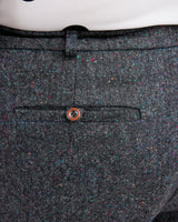 Close-up of a gray textured fabric with a button on a white background. These pants are the Meriam Trousers sewing pattern from Cashmerette.
