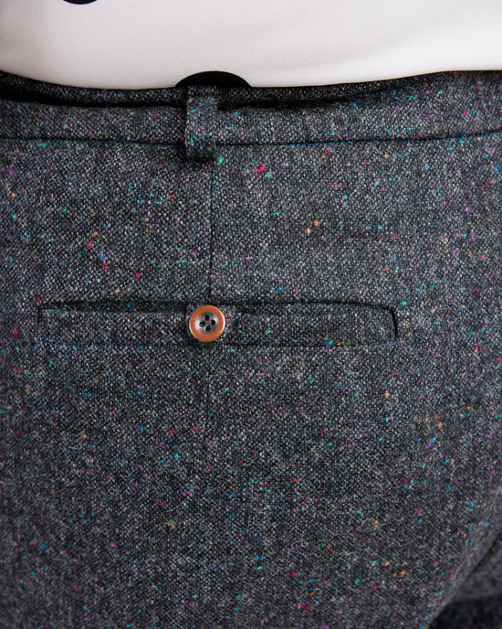 Close-up of a gray textured fabric with a button on a white background. These pants are the Meriam Trousers sewing pattern from Cashmerette.