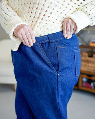 Person wearing blue jeans and a cream sweater in an indoor setting. These jeans are the Creston Jeans sewing pattern from Cashmerette.