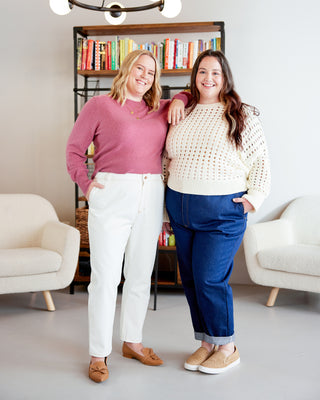 Two women standing in a living room with bookshelves in the background. These jeans are the Creston Jeans sewing pattern from Cashmerette.