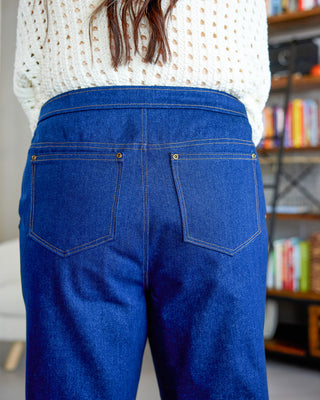 Person wearing blue jeans with a blurred background. These jeans are the Creston Jeans sewing pattern from Cashmerette.