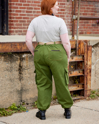 Person wearing green cargo pants standing in front of a brick wall. These pants are the Esmond Cargo Pants sewing pattern from Cashmerette.