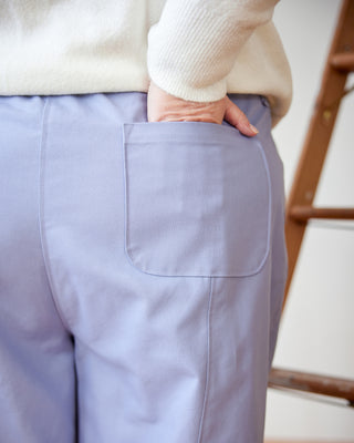 Person wearing light purple pants with a neutral background. These pants are the Vinton Pants sewing pattern from Cashmerette.