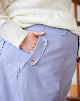 Light blue pants with a pocket detail worn by a person, blurred background. These pants are the Vinton Pants sewing pattern from Cashmerette.