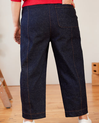 Person wearing dark blue wide-leg jeans indoors on a wooden floor. These pants are the Vinton Pants sewing pattern from Cashmerette.
