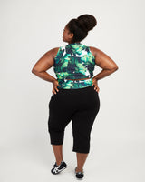 Person wearing a green leaf-patterned top and black capri pants on a white background. These leggings are the Belmont Leggings and Yoga Pants sewing pattern from Cashmerette.