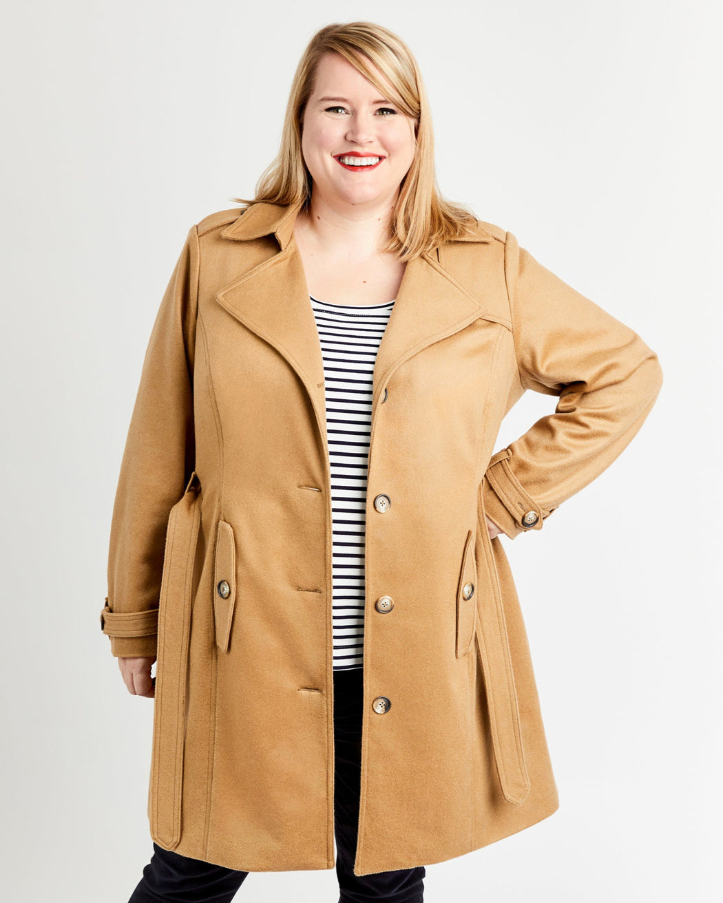 Woman wearing a tan coat on a white background. This coat is the Chilton Trench Coat sewing pattern from Cashmerette.