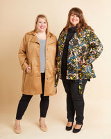 Two women wearing coats against a beige background. This coat is the Chilton Trench Coat sewing pattern from Cashmerette.
