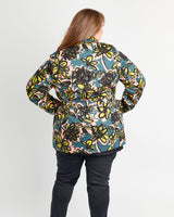 Person wearing a colorful floral jacket on a white background. This coat is the Chilton Trench Coat sewing pattern from Cashmerette.