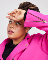 Person wearing a bright pink jacket with a white background. This biker jacket is the Canton Moto Jacket sewing pattern from Cashmerette.