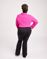 Person wearing a bright pink jacket and black pants on a white background. This biker jacket is the Canton Moto Jacket sewing pattern from Cashmerette.