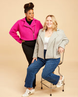 Two women posing together against a beige background. This biker jacket is the Canton Moto Jacket sewing pattern from Cashmerette.