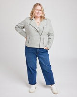 Woman wearing a gray jacket and blue jeans on a white background. This biker jacket is the Canton Moto Jacket sewing pattern from Cashmerette.