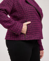 Person wearing a purple textured jacket with a plain background. This biker jacket is the Canton Moto Jacket sewing pattern from Cashmerette.