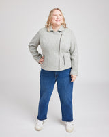 Person wearing a gray jacket and blue jeans on a white background. This biker jacket is the Canton Moto Jacket sewing pattern from Cashmerette.