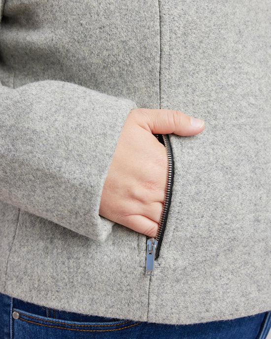Person wearing a gray coat with a hand reaching into the pocket. This biker jacket is the Canton Moto Jacket sewing pattern from Cashmerette.
