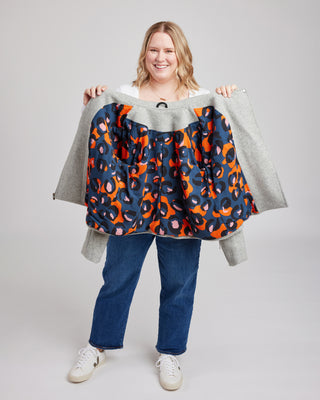 Person holding a colorful patterned jacket against a plain background. This biker jacket is the Canton Moto Jacket sewing pattern from Cashmerette.