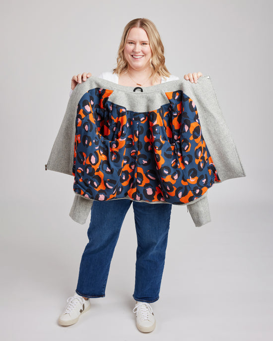 Person holding a colorful patterned jacket against a plain background. This biker jacket is the Canton Moto Jacket sewing pattern from Cashmerette.