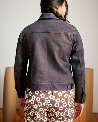 Person wearing a dark denim jacket with a plain background. This jacket is the Glover Jean Jacket sewing pattern from Cashmerette.