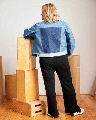 Person wearing a blue denim jacket with geometric pattern, standing next to stacked boxes indoors. This jacket is the Glover Jean Jacket sewing pattern from Cashmerette.