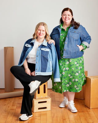 Two women wearing denim jackets in a room with cardboard boxes. This jacket is the Glover Jean Jacket sewing pattern from Cashmerette.