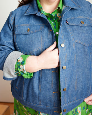 Person wearing a blue denim jacket with a green floral shirt underneath. This jacket is the Glover Jean Jacket sewing pattern from Cashmerette.