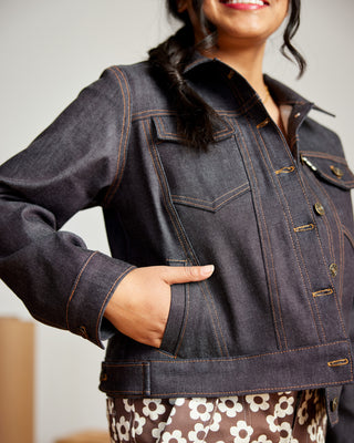 Person wearing a dark denim jacket with a blurred background. This jacket is the Glover Jean Jacket sewing pattern from Cashmerette.