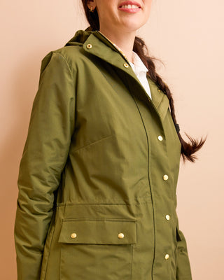 Green jacket worn by a person on a beige background.  This is the Marston Raincoat sewing pattern from Cashmerette Club.