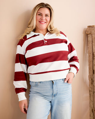 Woman wearing a red and white striped shirt with blue jeans against a beige wall. This is the Brookhaven Sweatshirt sewing pattern from Cashmerette.