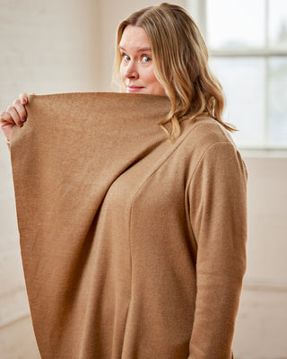 Woman holding a large brown fabric swatch in front of her face. This cardigan is the Westmore Cardigan sewing pattern from Cashmerette.