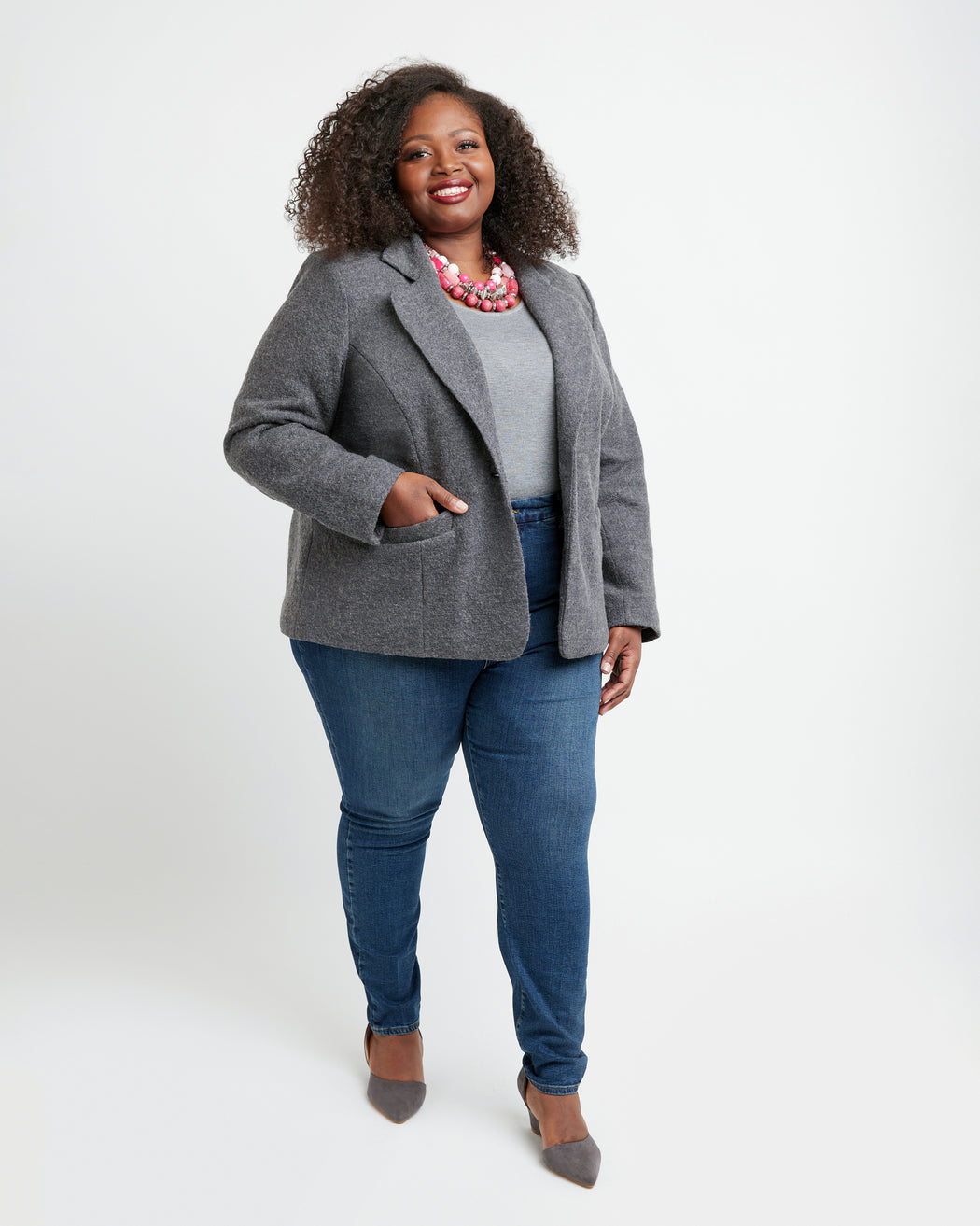 Woman wearing a gray blazer, white shirt, and blue jeans on a white background. This blazer is the Auburn Blazer sewing pattern from Cashmerette.