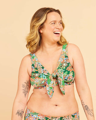 Woman wearing a floral bikini set on a beige background. This swimsuit is the Marblehead Swimsuit sewing pattern from Cashmerette.