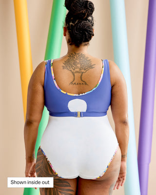 Woman wearing a swimsuit inside out with her back to the camera. This is the Truro Swimsuit sewing pattern from Cashmerette. In the bottom left corner in a white box is the text: "shown inside out".