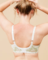 Woman wearing a floral bralette against a beige background. This bra is the Willowdale Bra sewing pattern from Cashmerette.