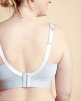 Light blue bra worn by a person on a beige background. This bralette is the Loftus Bralette sewing pattern from Cashmerette.