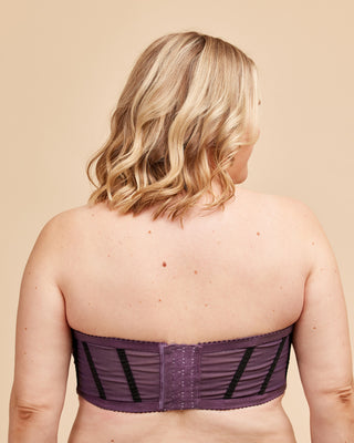 Person wearing a purple strapless top on a beige background. This bra is the Symmes Strapless Bra sewing pattern from Cashmerette.