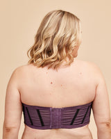 Person wearing a purple strapless top on a beige background. This bra is the Symmes Strapless Bra sewing pattern from Cashmerette.