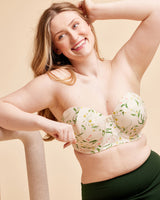 Woman wearing a floral strapless top against a beige background. This bra is the Symmes Strapless Bra sewing pattern from Cashmerette.