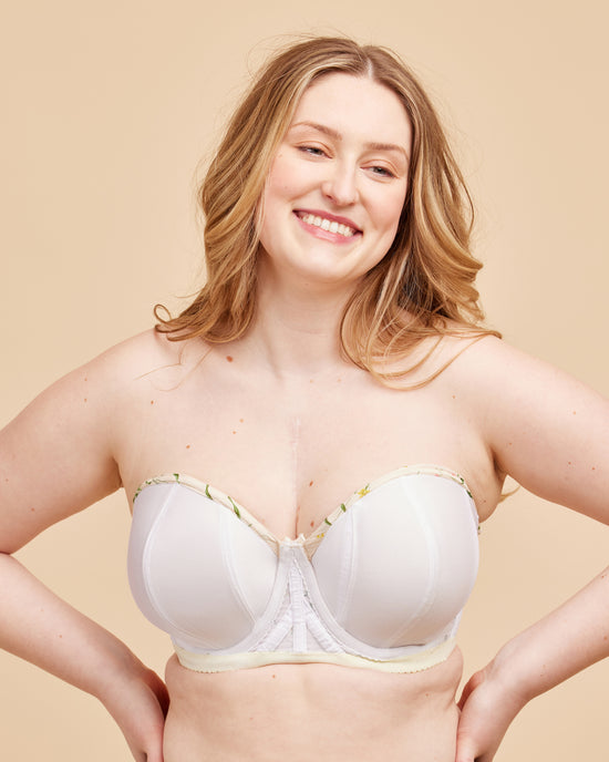 Woman wearing a white bra against a beige background. This bra is the Symmes Strapless Bra sewing pattern from Cashmerette.