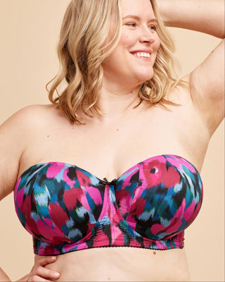 Woman wearing a colorful strapless top against a beige background. This bra is the Symmes Strapless Bra sewing pattern from Cashmerette.