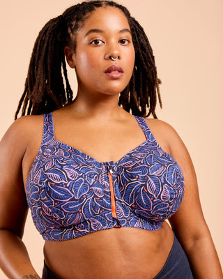 Woman wearing a blue patterned sports bra against a beige background. This is the Cashmerette Somerville Sports Bra sewing pattern for big boobs.