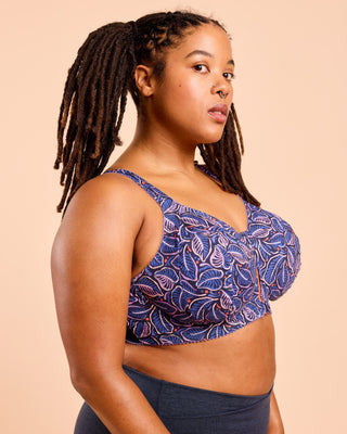 Woman wearing a blue patterned top against a beige background. This is the Cashmerette Somerville Sports Bra sewing pattern for big boobs.
