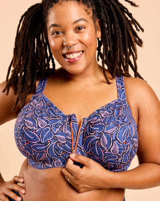 Woman wearing a blue patterned bra against a beige background. This is the Cashmerette Somerville Sports Bra sewing pattern for big boobs.