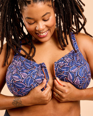 Woman wearing a blue patterned bra top against a beige background. This is the Cashmerette Somerville Sports Bra sewing pattern for big boobs.